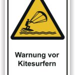Achtungsschild für Kitesurfen, zeigt einen Kitesurfer auf Wasser, mit dem Hinweis „Warnung vor Kitesurfen“ in deutscher Sprache.
