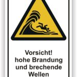 Warnschild mit der Aufschrift "Vorsicht! hohe Brandung und brechende Wellen", das auf gefährliche Bedingungen am Wasser hinweist.