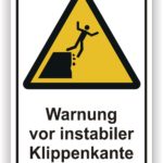 Achtungsschild mit der Aufschrift "Warnung vor instabiler Klippenkante", das auf gefährliche Kanten hinweist und vor möglichen Sturzgefahren warnt.