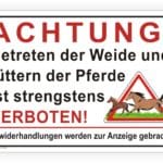Achtungsschild mit der Aufschrift "Betreten der Weide und Füttern der Pferde ist strengstens verboten!" und einer Warnung vor rechtlichen Konsequenzen.