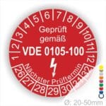DIN VDE 0105 Prüfplakette rund, Text "geprüft gemäß VDE 0105-100" Farbe- Rot Startjahr- 26 mit Elektro Pfeil, Monatszahlen Oben und Jahreszahlen Unten