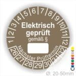 Pruefplakette mit Text Elektrisch geprüft gemäß Paragrapf als Zeichen und Beschriftungfeld zum eintragen des Paragraphs Farbe- Braun Startjahr- 26 mit Monatszahlen Oben und Jahreszahlen Unten Form ist Rund