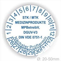 Prüfplaketten, Prüfetiketten rund, Farbe- Weiß, Text "STK/MTK MEDIZINPRODUKTE MPBetreibV, DGUV-V3, DIN VDE 0751-1 Nächster Prüftermin" in Blau. Startjahr- 26, Monatszahlen Oben und Jahreszahlen Unten in Kreisform. über den Jahreszahlen Text.