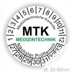 Prüfplaketten, Prüfetiketten rund, Farbe- Weiß, Text "Medizintechnische Kontrolle, MTK MEDIZINTECHNIK Nächster Prüftermin" in Schwarz. Startjahr- 27, Monatszahlen Oben und Jahreszahlen Unten in Kreisform. über den Jahreszahlen Text.