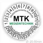 Prüfplaketten, Prüfetiketten rund, Farbe- Weiß, Text "Medizintechnische Kontrolle, MTK MEDIZINTECHNIK Nächster Prüftermin" in Schwarz. Startjahr- 29, Monatszahlen Oben und Jahreszahlen Unten in Kreisform. über den Jahreszahlen Text.