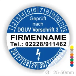Alt-Text: Prüfplakette mit dem Hinweis "Geprüft nach DGUV Vorschrift 3", Platz für Firmennamen und Telefonnummer, mit farbigen Markierungen zur Kennzeichnung, Durchmesser von 25-50mm.