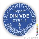 Prüfplaketten rund, Farbe- Blau, Text "Geprüft gemäß DIN VDE 0751-1" in Weiß danach ein Elektro- Pfeil in Weiß, Startjahr- 26, Monatszahlen Oben und Jahreszahlen Unten in Kreisform. Über den Jahreszahlen Text "Nächster Prüftermin"