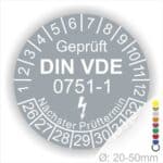 Prüfplaketten rund, Farbe- Grau, Text "Geprüft gemäß DIN VDE 0751-1" in Weiß danach ein Elektro- Pfeil in Weiß, Startjahr- 26, Monatszahlen Oben und Jahreszahlen Unten in Kreisform. Über den Jahreszahlen Text "Nächster Prüftermin"