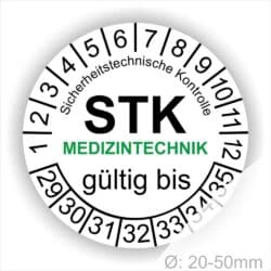 Prüfetiketten rund, Farbe- Weiß, Text "Sicherheitstechnische Kontrolle, STK MEDIZINTECHNIK gültig bis" in Schwarz. Startjahr- 29, Monatszahlen Oben und Jahreszahlen Unten in Kreisform. über den Jahreszahlen Text.