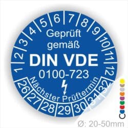 Prüfplakette, Prüfetikette rund, Farbe- Blau, Text "Geprüft gemäß VDE 0100-0723" in Weiß danach ein Elektro- Pfeil in Weiß, Startjahr- 26, Monatszahlen Oben und Jahreszahlen Unten in Kreisform. Über den Jahreszahlen Text "Nächster Prüftermin"
