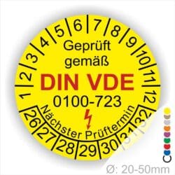 Prüfplakette, Prüfetikette rund, Farbe- Gelb, Text "Geprüft gemäß VDE 0100-723" in Schwarz danach ein Elektro- Pfeil in Rot, Startjahr- 26, Monatszahlen Oben und Jahreszahlen Unten in Kreisform. Über den Jahreszahlen Text "Nächster Prüftermin"