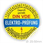 Prüfplaketten rund, Farbe- Gelb in der Mitte ein Streifen in Blau, Text oberer Teil "Geprüft gemäß DIN-VDE" in Schwarz. Mittig Streifen in Blau mit dem Text " ELEKTRO-PRÜFUNG", Danach Elektropfeil in Rot Startjahr- 28, Monatszahlen Oben und Jahreszahlen Unten in Kreisform. Über den Jahreszahlen Text "Nächster Prüftermin"