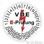 Prüfplaketten rund, Farbe- Weiß, Text "VDE E-Prüfung" in Schwarz in Hinergrund ein Elektro- Pfeil in Rot, Startjahr- 24, Monatszahlen Oben und Jahreszahlen Unten in Kreisform. Über den Jahreszahlen Text "Nächster Prüftermin"