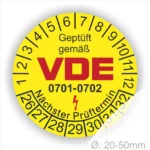 Gelbes Prüflabel mit der Aufschrift "Geprüft gemäß VDE 0701-0702" und Angaben zum nächsten Prüftermin, geeignet für elektrische Geräte im Durchmesser von 20-50 mm.
