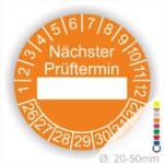 Prüfplakette, Prüfetikett rund, Farbe- Orange, Text "Nächster Prüftermin" in Weiß. Als nächstes kommt ein Beschriftungfeld / Leerfeld in Farbe Weiß. Startjahr- 26, Monatszahlen Oben und Jahreszahlen Unten in Kreisform.