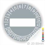 Prüfplaketten, Prüfetikett rund, Farbe- Grau, Text " in Weiß. Als nächstes kommt ein Beschriftungfeld / Leerfeld in Farbe Weiß. Startjahr- 26, Monatszahlen Oben und Jahreszahlen Unten in Kreisform.