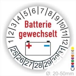 Prüfaufkleber Batterie gewechselt rund, Farbe- Weiß, Text "Batterie gewechselt" in Rot. Icon Batterie, Startjahr- 25, Monatszahlen Oben und Jahreszahlen Unten in Kreisform.