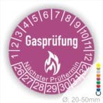 Prüfplaketten, Prüfetiketten rund, Farbe- Lila, Text "Gasprüfung" in Weiß danach eine Flamme als Pictogramm oder Icon in Weiß, Startjahr- 26, Monatszahlen Oben und Jahreszahlen Unten in Kreisform. Über den Jahreszahlen Text "Nächster Prüftermin"