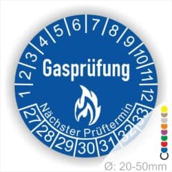 Prüfplaketten, Prüfaukleber rund, Farbe- Blau, Text "Gasprüfung" in Weiß danach eine Flamme als Pictogramm oder Icon in Weiß, Startjahr- 27, Monatszahlen Oben und Jahreszahlen Unten in Kreisform. Über den Jahreszahlen Text "Nächster Prüftermin"