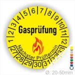 Prüfplaketten, Prüfaukleber rund, Farbe- Gelb, Text "Gasprüfung" in Schwarz danach eine Flamme als Pictogramm oder Icon in Rot, Startjahr- 27, Monatszahlen Oben und Jahreszahlen Unten in Kreisform. Über den Jahreszahlen Text "Nächster Prüftermin"