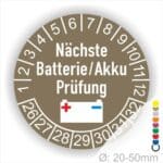 Prüfetiketten, Prüfplakette rund, Farbe- Braun, Text "Nächste Batterie/Akku Prüfung" in Weiß. Icon Batterie, Startjahr- 25, Monatszahlen Oben und Jahreszahlen Unten in Kreisform.