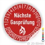 Prüfplaketten rund, Farbe- Rot, Text "Nächste Gasprüfung" in Weiß danach eine Flamme als Pictogramm oder Icon in Weiß, Startjahr- 25, Monatszahlen Oben und Jahreszahlen Unten in Kreisform.