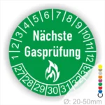 Runder Aufkleber in Gruen zur Kennzeichnung der nächsten Gasprüfung mit Feuer-Icon und Zahlen von 1 bis 12 Monatszahlen und 27-33 Jahreszahlen. Ideal für die Sicherheit von Gasinstallationen. Durchmesser 20-50 mm.
