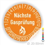 Runder Aufkleber in Orange zur Kennzeichnung der nächsten Gasprüfung mit Feuer-Icon und Zahlen von 1 bis 12 Monatszahlen und 27-33 Jahreszahlen. Ideal für die Sicherheit von Gasinstallationen. Durchmesser 20-50 mm.