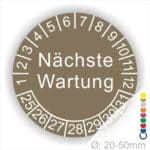 Prüfplaketten, Prüfetiketten rund, Farbe- Braun, Text "Nächste Wartung" in Weiß. Startjahr- 25, Monatszahlen Oben und Jahreszahlen Unten in Kreisform.