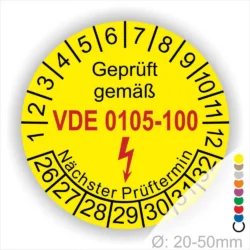 Gelbes Prüfplakett mit der Aufschrift "Geprüft gemäß VDE 0105-100" und Angaben zum nächsten Prüftermin sowie Durchmesser von 20-50 mm.