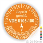 VDE Prüfplakette in orange mit der Aufschrift "Geprüft gemäß VDE 0105-100" und Prüfterminanzeige, geeignet für Geräte mit einem Durchmesser von 20-50 mm.