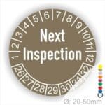 Prüfetiketten, Prüfaukleber rund, Farbe- Braun, Text auf Englisch "Next Inspection" in Weiß. Startjahr- 26, Monatszahlen Oben und Jahreszahlen Unten in Kreisform.