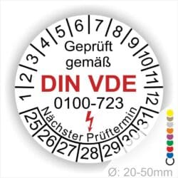 Prüfplaketten rund, Farbe- Weiß, Text "Geprüft gemäß VDE 0100-723" in Schwarz danach ein Elektro- Pfeil in Rot, Startjahr- 25, Monatszahlen Oben und Jahreszahlen Unten in Kreisform. Über den Jahreszahlen Text "Nächster Prüftermin"