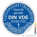Prüfaufkleber rund, Farbe- Blau, Text "Geprüft gemäß VDE 0100-0723" in Weiß danach ein Elektro- Pfeil in Weiß, Startjahr- 27, Monatszahlen Oben und Jahreszahlen Unten in Kreisform. Über den Jahreszahlen Text "Nächster Prüftermin"