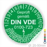 Prüfaufkleber rund, Farbe- Grün, Text "Geprüft gemäß VDE 0100-0723" in Weiß danach ein Elektro- Pfeil in Weiß, Startjahr- 27, Monatszahlen Oben und Jahreszahlen Unten in Kreisform. Über den Jahreszahlen Text "Nächster Prüftermin"