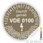 Prüfplaketten rund Farbe- Braun, Text "Geprüft gemäß VDE 0100" in Weiß danach ein Elektro- Pfeil in Weiß, Startjahr- 25, Monatszahlen Oben und Jahreszahlen Unten in Kreisform. Über den Jahreszahlen Text "Nächster Prüftermin"