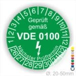 Prüfplaketten rund Farbe- Grün, Text "Geprüft gemäß VDE 0100" in Weiß danach ein Elektro- Pfeil in Weiß, Startjahr- 26, Monatszahlen Oben und Jahreszahlen Unten in Kreisform. Über den Jahreszahlen Text "Nächster Prüftermin"