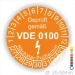 Prüfsiegel gemäß VDE 0100 auf orangefarbenem Hintergrund, zeigt den nächsten Prüftermin und die Prüfintervalle von 1 bis 12 sowie 27 bis 33, geeignet für Durchmesser von 20-50 mm.