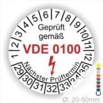 Prüfaufkleber, Prüfsiegel rund, Farbe- Weiß, Text "Geprüft gemäß VDE 0100" in Schwarz danach ein Elektro- Pfeil in Rot, Startjahr- 29, Monatszahlen Oben und Jahreszahlen Unten in Kreisform. Über den Jahreszahlen Text "Nächster Prüftermin"