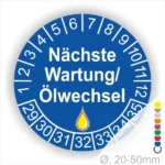 Prüfetiketten, Wartungsplakette rund, Farbe- Blau, Text "Nächste Wartung/Ölwechsel" in Weiß. Startjahr- 29, Monatszahlen Oben und Jahreszahlen Unten in Kreisform, über den Jahreszahlen ein Öltropfen als Icon/Piktogramm in Gelb.