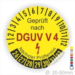 Gelbes Prüfzeichen mit der Aufschrift „Geprüft nach DGUV V4“ und Angaben zum nächsten Prüftermin. Durchmesser des Aufklebers: 20-50 mm.