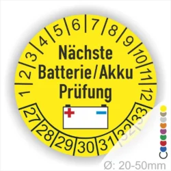 Gelbes Prüflabel für die nächste Batterie- oder Akkuprüfung, mit einem Durchmesser von 20-50 mm. Das Design zeigt eine Batterie-Grafik und eine nummerierte Skala für Prüfintervalle.