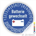 Prüfaufkleber Batterie gewechselt rund, Farbe- Weiß, Text "Batterie gewechselt" in Weiss. Icon Batterie, Startjahr- 26, Monatszahlen Oben und Jahreszahlen Unten in Kreisform.