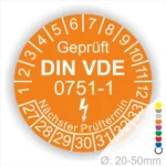 Prüfsiegel nach DIN VDE 0751-1 in orange mit Prüfnummern und nächstem Prüftermin, Durchmesser 20-50 mm.