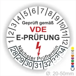 VDE E-Prüfungslabel mit nächstem Prüfungstermin, Durchmesser 20-50 mm, zeigt Sicherheitsstandard für elektrische Geräte an.